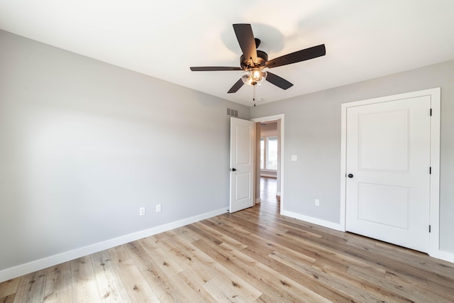 unfurnished bedroom featuring baseboards, visible vents, a ceiling fan, and light wood-style floors