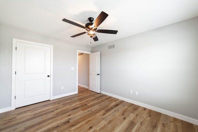 unfurnished bedroom with ceiling fan, visible vents, light wood-type flooring, and baseboards
