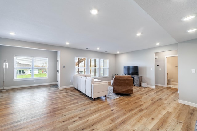 living room featuring recessed lighting, light wood-style flooring, and plenty of natural light