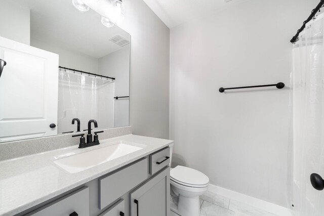 bathroom featuring vanity, toilet, marble finish floor, visible vents, and baseboards