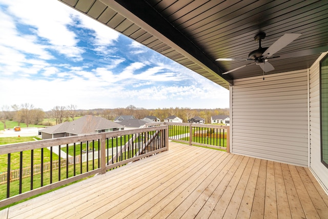 wooden deck with a residential view and a ceiling fan