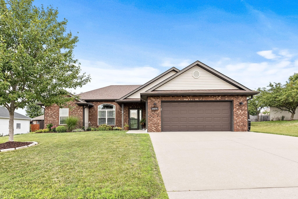 ranch-style house with driveway, brick siding, a front lawn, and a garage
