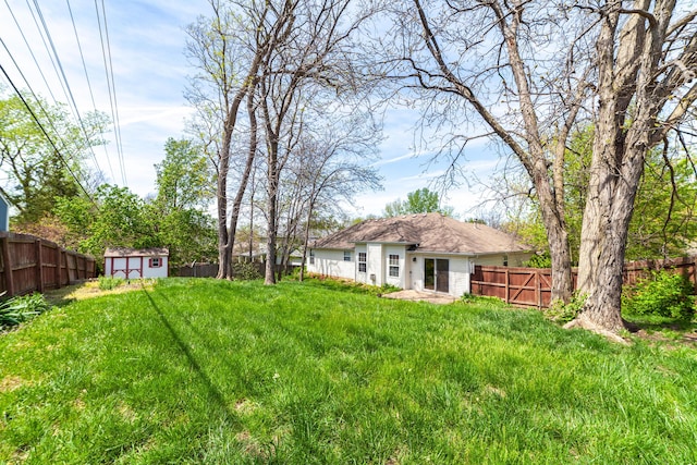 view of yard featuring an outbuilding, a storage shed, and a fenced backyard