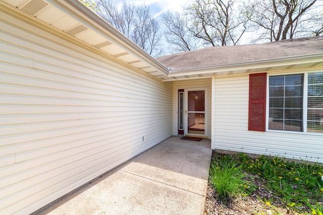 property entrance featuring a shingled roof