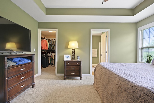 carpeted bedroom with connected bathroom, a spacious closet, baseboards, and a closet