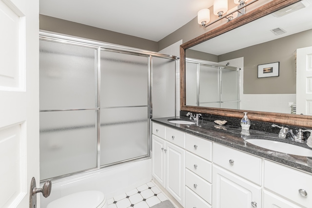 403 Westmount Ave, Columbia, MO 65203 - full bathroom with tile patterned floors, double vanity, enclosed tub / shower combo, and toilet