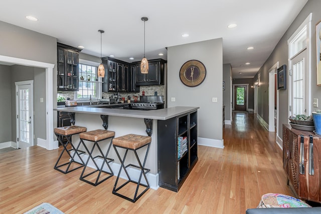 403 Westmount Ave, Columbia, MO 65203 - kitchen with open shelves, light wood-type flooring, a kitchen bar, tasteful backsplash, and recessed lighting