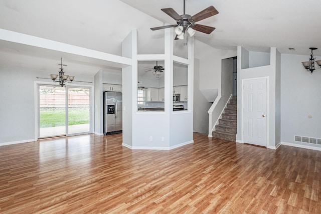4983 N Montgomery Dr, Columbia, MO 65202 - unfurnished living room with a chandelier, stairs, baseboards, and high vaulted ceiling