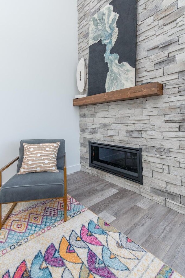 detailed view of wood finished floors, a fireplace, and baseboards