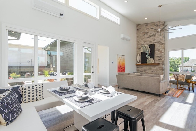 dining area with a towering ceiling, a ceiling fan, wood finished floors, and recessed lighting