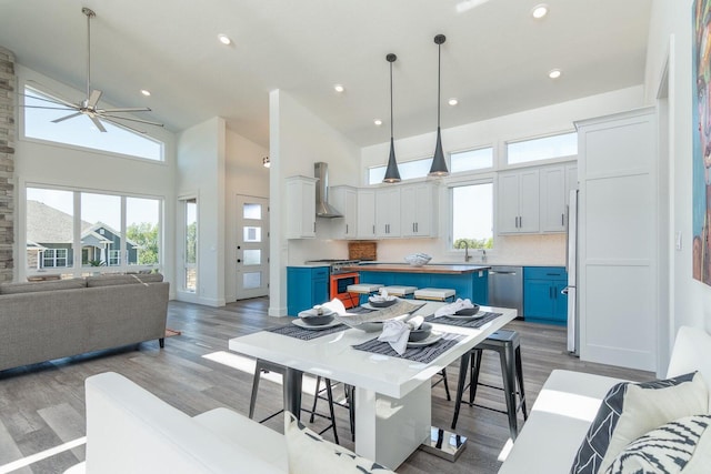 dining area featuring high vaulted ceiling, light wood-style flooring, a ceiling fan, and recessed lighting