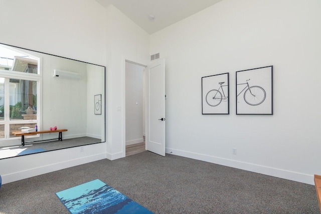 unfurnished bedroom featuring carpet floors, baseboards, and a towering ceiling