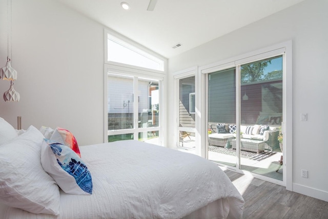 bedroom with access to outside, multiple windows, wood finished floors, baseboards, and vaulted ceiling