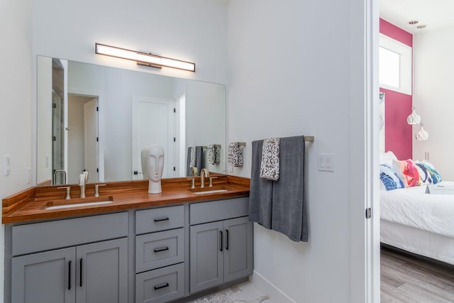 ensuite bathroom with double vanity and baseboards