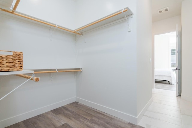 walk in closet with light wood-style flooring