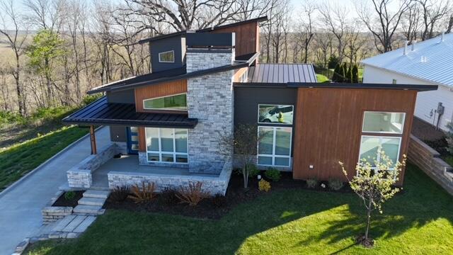 back of property featuring a standing seam roof, metal roof, and a lawn