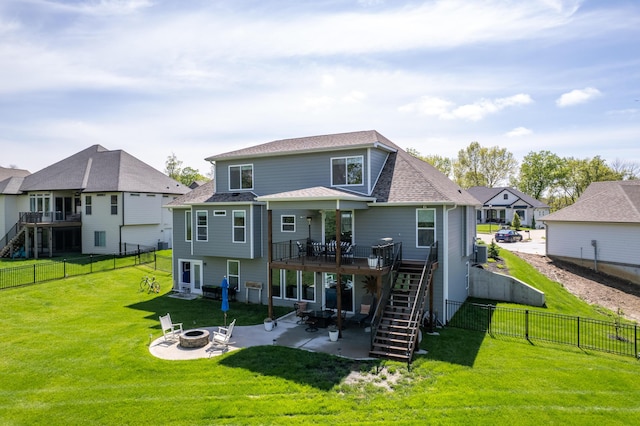 back of house featuring a deck, stairway, a fenced backyard, an outdoor fire pit, and a yard