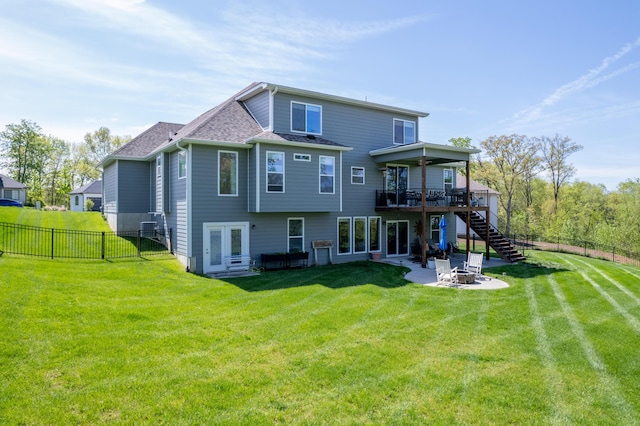 back of house with a wooden deck, a fenced backyard, a patio area, an outdoor fire pit, and stairway