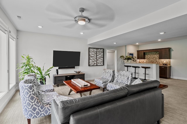 living area featuring a ceiling fan, baseboards, recessed lighting, and light carpet