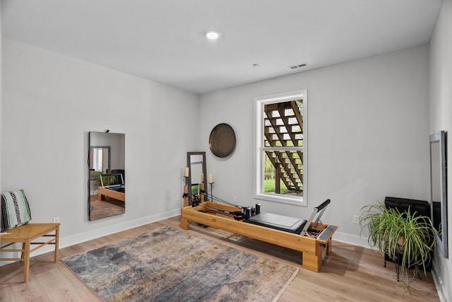 workout room with baseboards, wood finished floors, and visible vents