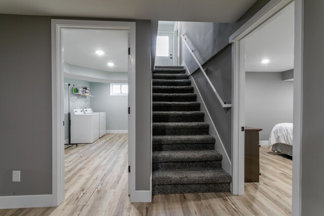 stairway with baseboards, plenty of natural light, independent washer and dryer, and wood finished floors
