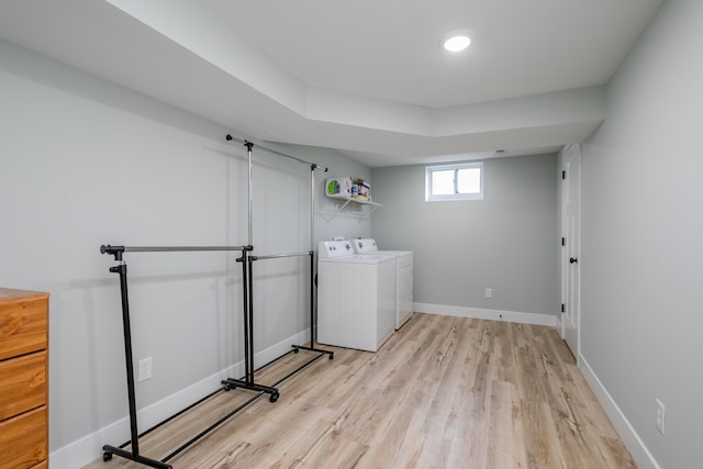 washroom featuring baseboards, laundry area, light wood finished floors, and independent washer and dryer