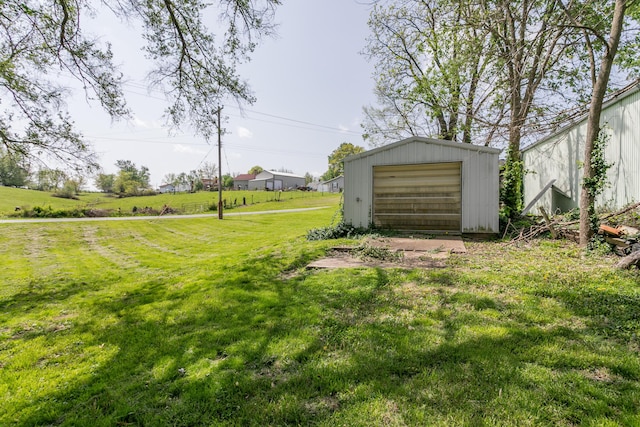view of yard with a detached garage and an outdoor structure