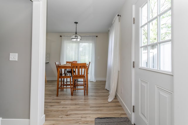 dining room with baseboards and light wood finished floors
