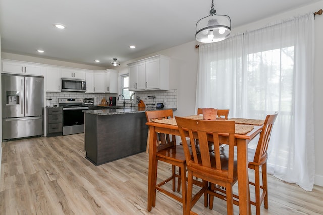 kitchen with a sink, backsplash, stainless steel appliances, and a peninsula