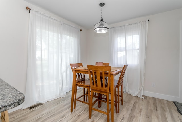 dining area with plenty of natural light, light wood finished floors, and visible vents