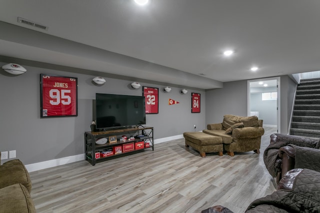 living room with light wood-style floors, baseboards, stairway, and visible vents