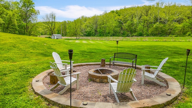 7751 W Old Barclay Creek Ln, Columbia, MO 65202 - view of green lawn with an outdoor fire pit and a view of trees