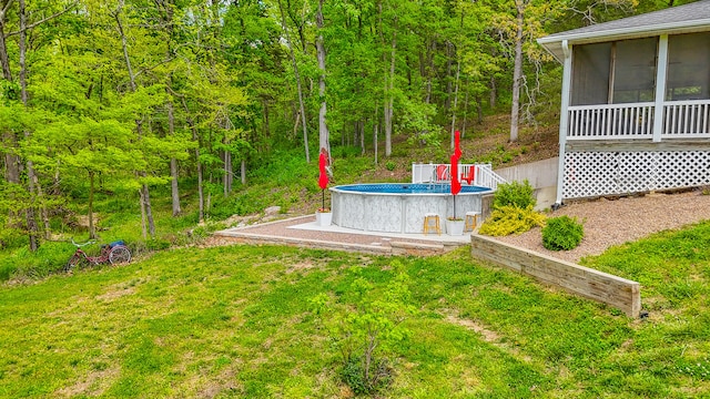 7751 W Old Barclay Creek Ln, Columbia, MO 65202 - view of green lawn with a sunroom, an outdoor pool, and a view of trees