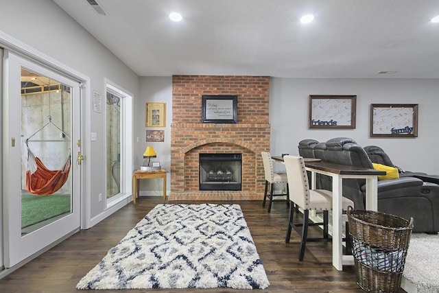 7751 W Old Barclay Creek Ln, Columbia, MO 65202 - living area featuring dark wood-style floors, a brick fireplace, and recessed lighting