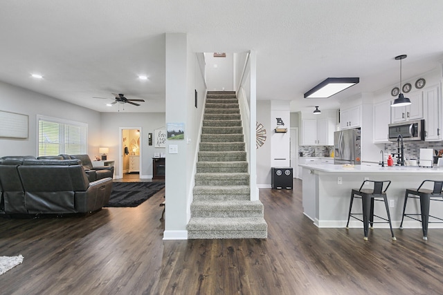 7751 W Old Barclay Creek Ln, Columbia, MO 65202 - living room featuring stairs, dark wood-style floors, ceiling fan, baseboards, and recessed lighting