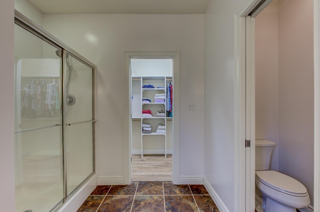 1600 Andretti Cir, Columbia, MO 65201 - bathroom featuring a shower stall, toilet, baseboards, and a spacious closet