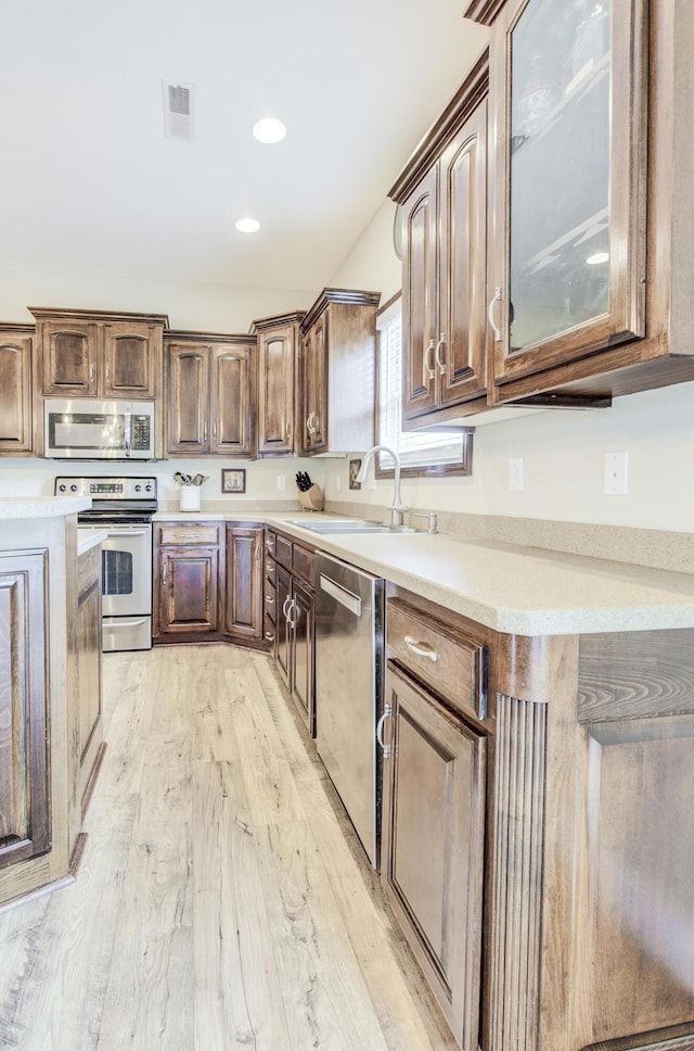 1600 Andretti Cir, Columbia, MO 65201 - kitchen featuring stainless steel appliances, a sink, light wood-style flooring, light countertops, and glass insert cabinets