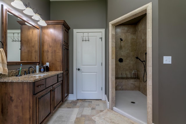 6507 Crooked Switch Ct, Columbia, MO 65201 - bathroom featuring a tile shower, baseboards, vanity, and stone finish flooring