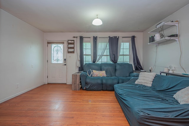 living room featuring baseboards, a wealth of natural light, and light wood-type flooring