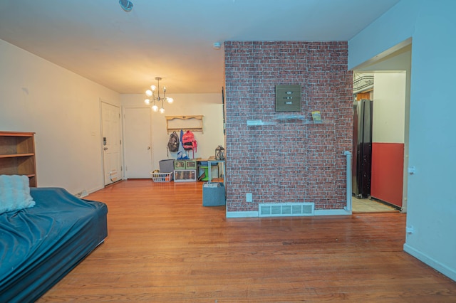 living area featuring visible vents, baseboards, wood finished floors, and a chandelier
