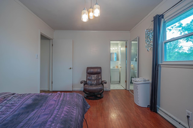 bedroom featuring baseboard heating, ensuite bath, baseboards, wood finished floors, and ornamental molding