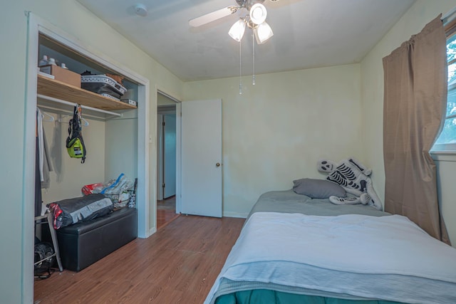 bedroom with baseboards, a ceiling fan, a closet, and wood finished floors
