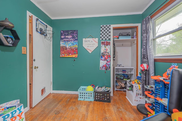playroom featuring crown molding, baseboards, and wood-type flooring