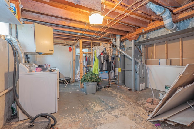 unfinished basement featuring heating unit, gas water heater, and washer and dryer