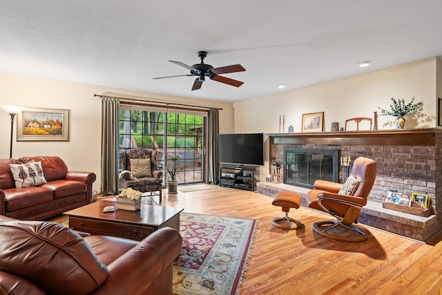living room with ceiling fan, a fireplace, recessed lighting, and wood finished floors