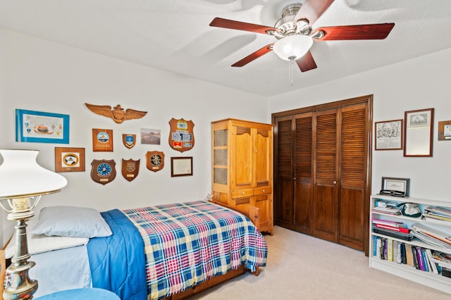 bedroom featuring ceiling fan, light carpet, and a closet