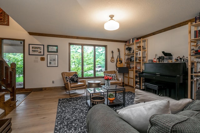 living area with baseboards, ornamental molding, and wood finished floors