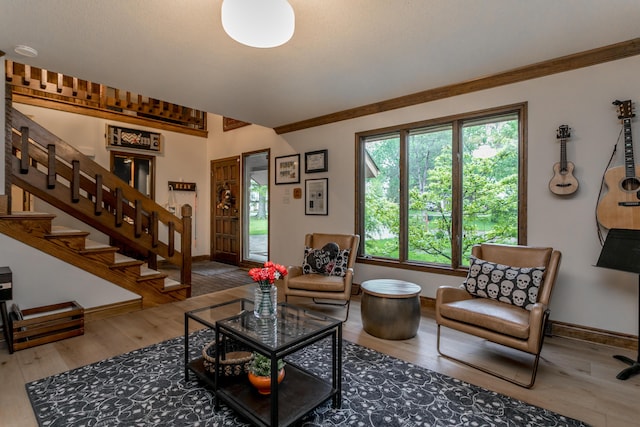 living room featuring stairway, baseboards, and wood finished floors