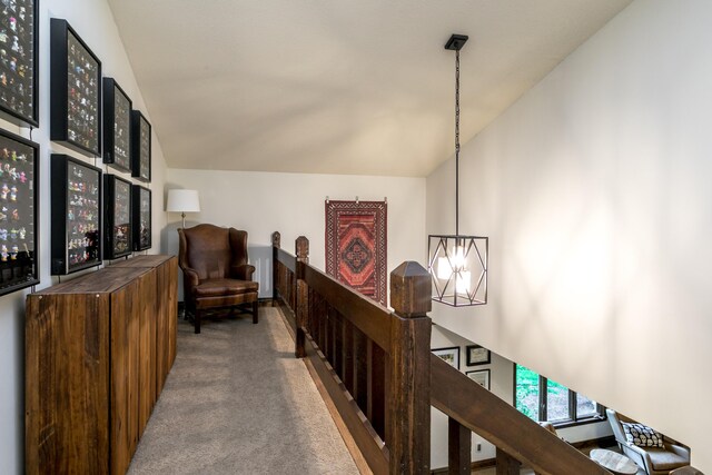 hallway with carpet flooring and vaulted ceiling