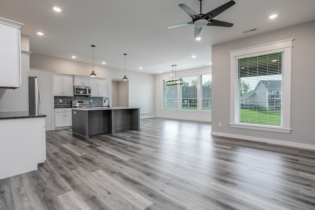 15070 Ada Dr, Hallsville, MO 65255 - kitchen with decorative backsplash, visible vents, wood finished floors, stainless steel appliances, and recessed lighting